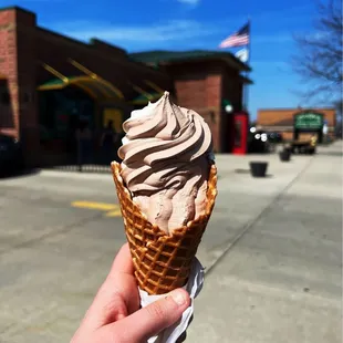 a hand holding an ice cream cone