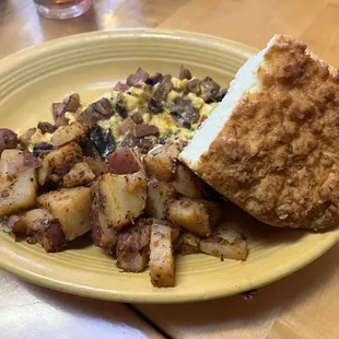 a plate of fried potatoes and a biscuit
