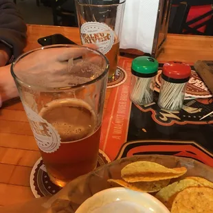 a glass of beer and chips