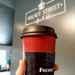 a hand holding a coffee cup