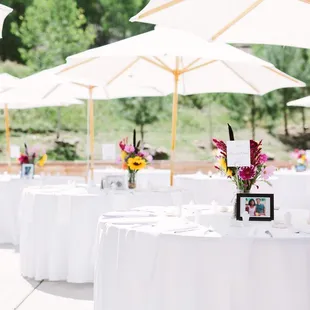 Table set up and umbrellas done by Walter Burke Catering. Flower arrangements, table numbers, and framed photos were set privately.