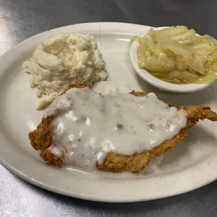 Country Fried Chicken Steak with mash potatoes, cabbage and gravy.