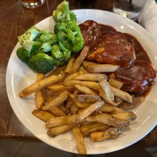 Bbq chicken breast special with steamed &apos;vegetables&apos; and french fries.