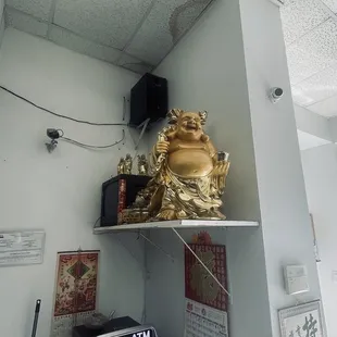 a shelf with a statue of a buddha on it