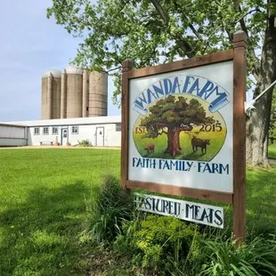 a sign in front of a farm
