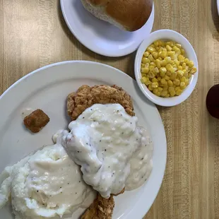 Chicken fried steak with gravy and mashed potatoes. Sides: corn, roll.