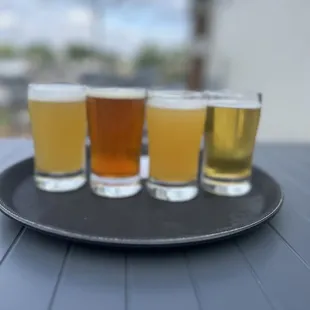 four glasses of beer on a tray