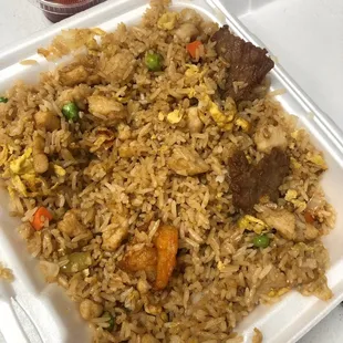 a plate of fried rice with meat and vegetables