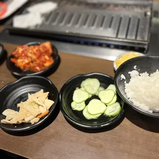 Kimchi, Fishcake, pickled cucumber and steamed rice. Endless sides to add to the meats you choose.