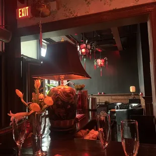 a table with wine glasses and a vase of flowers