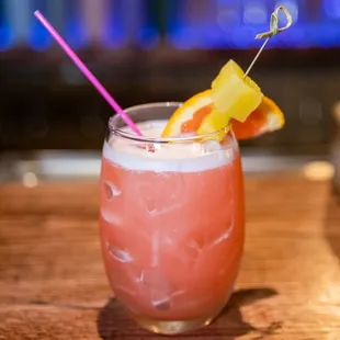 a pink drink with a pineapple garnish