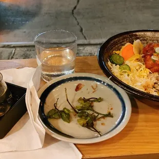 a table with a bowl of food and a glass of water