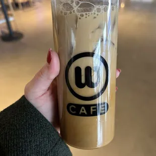 a hand holding a cup of iced coffee