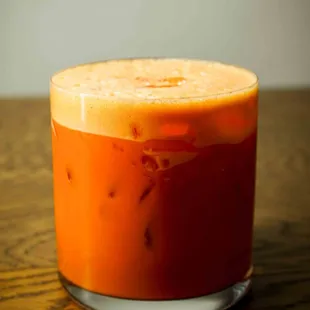 a glass of orange juice on a wooden table