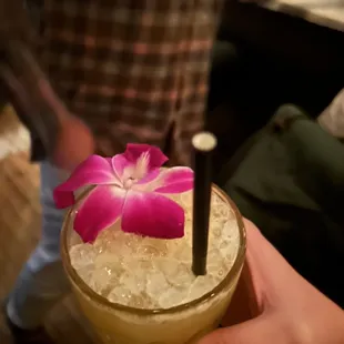 a person holding a drink with a flower on it