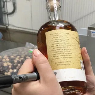 a person holding a bottle of bourbon