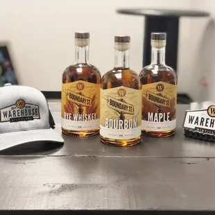 three bottles of bourbon and a hat