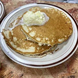 a plate of pancakes with butter and syrup