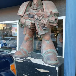 a statue of a warhammer holding a machine gun