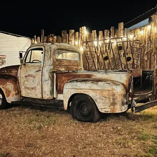 an old truck parked in front of a barn