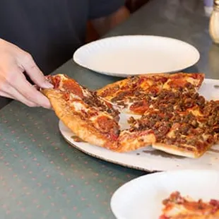 a group of people eating pizza