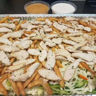 a tray of chicken, lettuce, and french fries