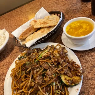 a plate of noodles and a bowl of soup