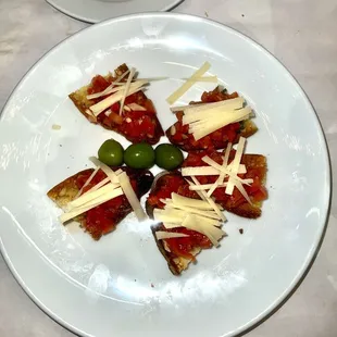 a plate of appetizers with olives and cheese