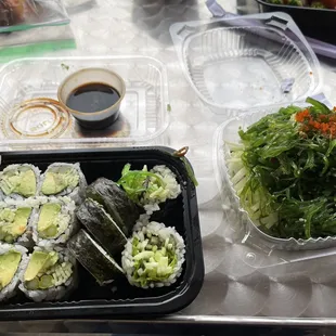 sushi and a salad on a tray