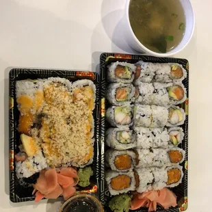two trays of sushi and a bowl of soup