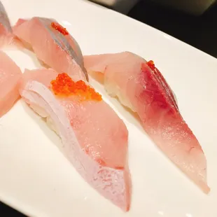 three pieces of sushi on a white plate