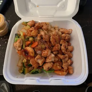 a takeout container of chicken and vegetables