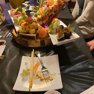 a plate of sushi and chopsticks on a table