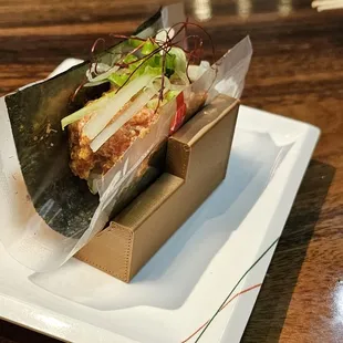 a sandwich wrapped in plastic on a plate