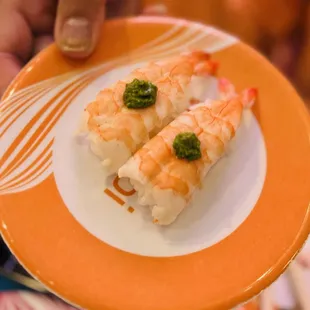a person holding a plate of sushi