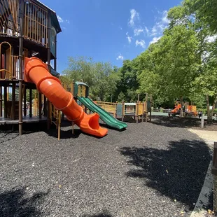 Big play structure with parking lot behind and small structure to right