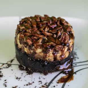 a cheesecake with pecans and chocolate sauce