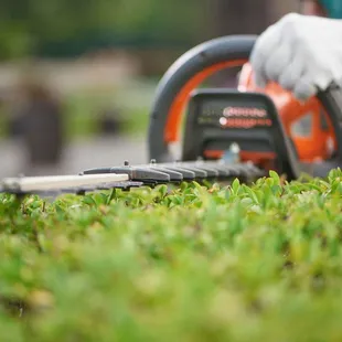 a person cutting grass with a chainsaw