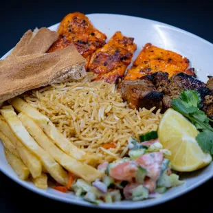 a plate of food with meat, rice, and french fries