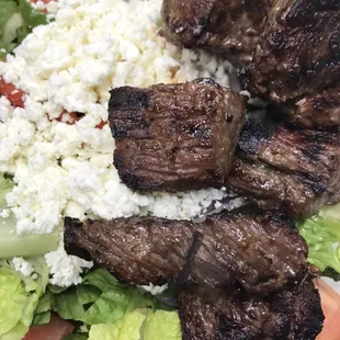 Delicious steak tip salad over garden or Greek salad.