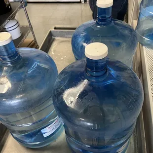 three large bottles of water on a tray