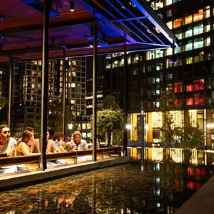 people sitting at tables in a city at night