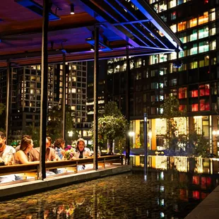 people sitting at tables in a city at night