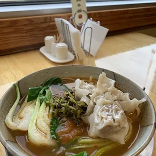 a bowl of soup with dumplings