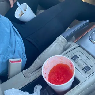 a person sitting in a car with a cup of coffee