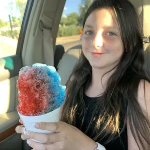 a girl in a car holding an ice cream cone