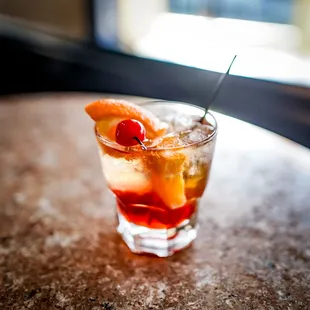 a drink with a cherry garnish