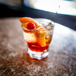 a drink with a cherry garnish