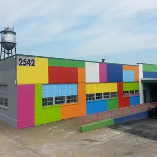 a multicolored building with a water tower in the background