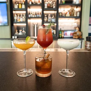 three cocktails on a bar